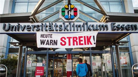 Ein Plakat mit der Aufschrift „Heute Warnstreik“ hängt vor der Universitätsklinikum.