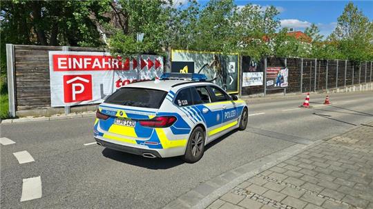 Ein Polizeiauto steht in der Zufahrt zur Tiefgarage eines Baumarkts, wo die Leiche einer Frau im Kofferraum eines Autos gefunden worden ist.