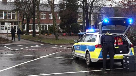 Ein Polizeiauto steht vor dem Gebäude einer  Grund- und Hauptschule in Lüdingworth. Dort hat ein Mädchen ein anderes mit einem Messer schwer verletzt.
