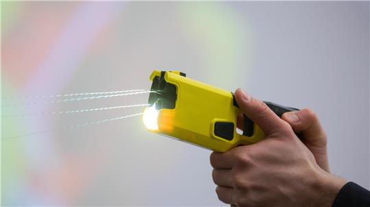 Ein Polizeibeamter demonstriert einen Schuss mit einem Taser. Das Gerät sendet nach Abschuss zweier Elektroden Stromimpulse ab. Foto: picture alliance/dpa