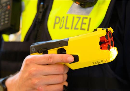 Ein Polizeibeamter hält im Rahmen der Pressekonferenz des Polizeipräsidenten einen Taser in der Hand. Foto: Soeren Stache/dpa-Zentralbild/dpa