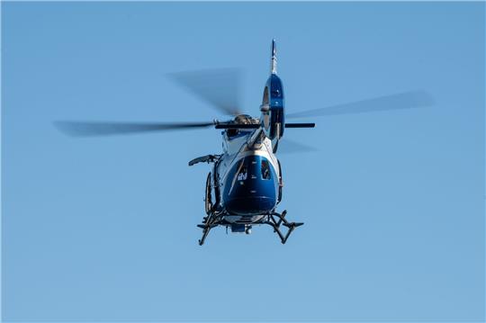 Ein Polizeihubschrauber fliegt am Himmel.