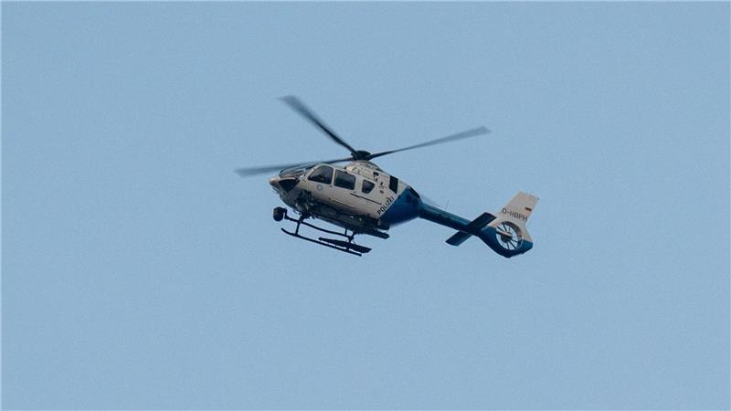 Zwei Tote bei zwei Feiern in Bayern - Täter weiter flüchtig Ein Polizeihubschrauber fliegt über den Ortsrand in Parsberg.