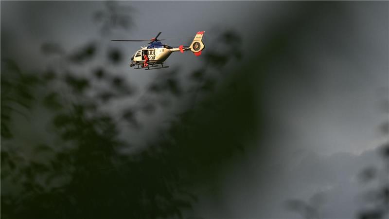 Ein Polizeihubschrauber kreist über der Absturzstelle eines Bundeswehrhubschraubers in Sachsen, auf der Suche nach einem noch Vermissten.