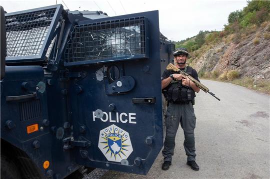 Ein Polizist aus dem Kosovo sichert das Gelände nach den schweren Kämpfen zwischen serbischen Paramilitärs und kosovarischen Polizisten.