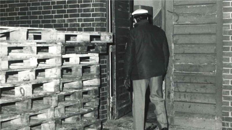 Ein Polizist betritt die Fischhalle XI im Cuxhavener Fischereihafen, Schauplatz des ungeklärten Doppelmords von 1986.