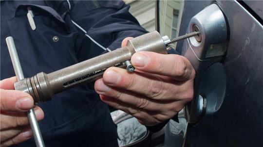 Ein Polizist demonstriert mit einem Ziehfix, dem Standardwerkzeug eines Autodiebes, wie ein Autodieb vorgeht.