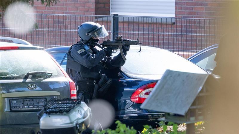 Ein Polizist hält in Moers eine Maschinenpistole im Anschlag. Zuvor war es zu einer Auseinandersetzung am Haus einer religiösen Gemeinde gekommen.