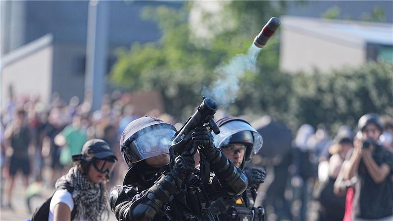 Ein Polizist in Schutzausstattung feuert bei den Protesten gegen den G7 Gipfel in Evian in Frankreich etwas in die Luft. Die Demonstrationen finden in der auf der Schweizer Seite des Genfersee gelegenen Stadt Genf statt.