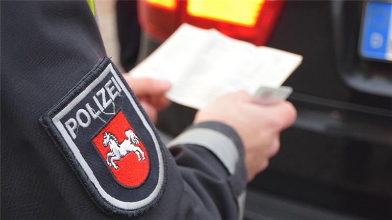 Ein Polizist kontrolliert Fahrzeugpapiere. Foto: Polizei