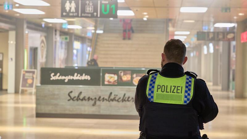 Ein Polizist steht in der verrauchten Shoppingmeile.