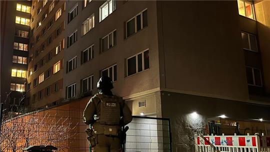 Ein Polizist steht vor dem Studentenwohnheim in Berlin-Friedrichshain, in dem eine Wohnung durchsucht wurde.