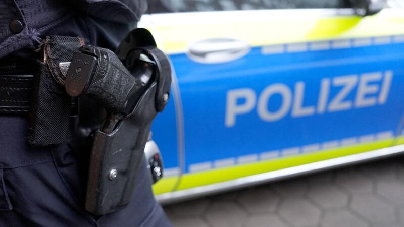 Weniger Straftaten, aber mehr Raub und Vergewaltigungen Ein Polizist steht vor einem Einsatzfahrzeug der Polizei.