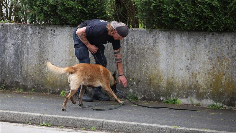 Polizei schießt bei Düsseldorf auf Bewaffneten Ein Polizist sucht mit einem Spürhund nach Hinweisen.