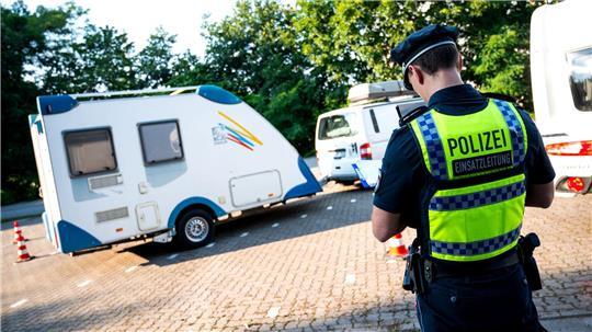 Ein Polizist überprüft während einer Verkehrskontrolle ein Wohnwagen-Gespann. (Symbolbild)
