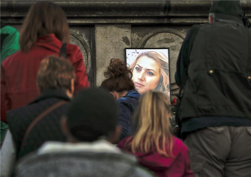 Ein Porträt der getöteten Fernsehreporterin Wiktorija Marinowa steht während einer Mahnwache auf dem Freiheitsdenkmal. Foto: Vadim Ghirda/AP/dpa
