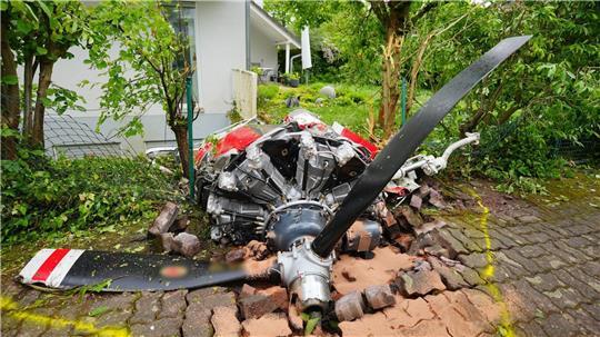 Ein Propeller der Maschine liegt vor einem Wohnhaus.
