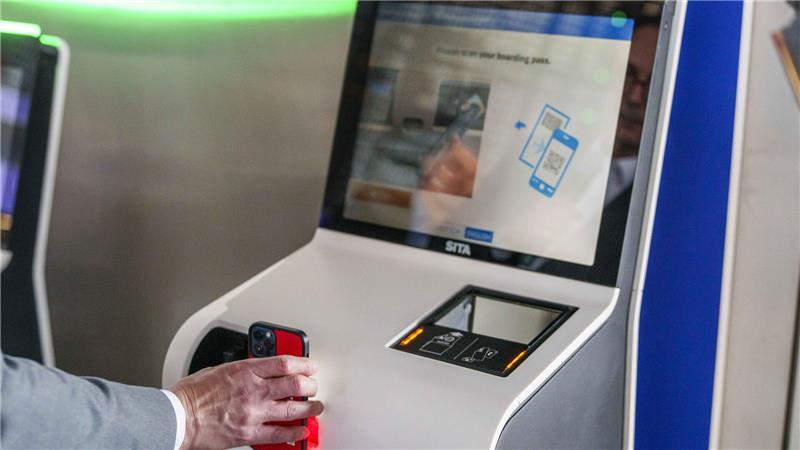 Ein QR-Code mit Reisedaten wird vom Scanner des Check-in Automaten gelesen.