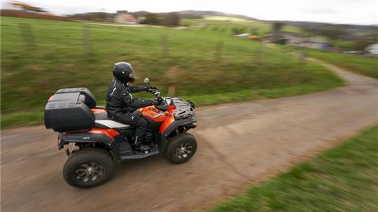 Ein Quadfahrer ist auf einer Landstraße unterwegs