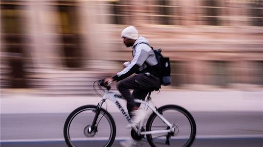 Ein Radfahrer fährt am frühen Morgen auf einem Radschnellweg.