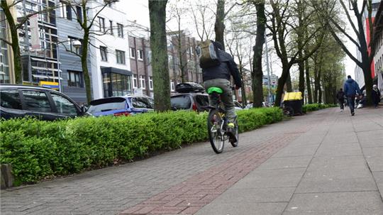 Ein Radfahrer fährt auf dem baulich gekennzeichneten Radweg die Bahnhofstraße entlang. Er dürfte auch die Fahrbahn nutzen.