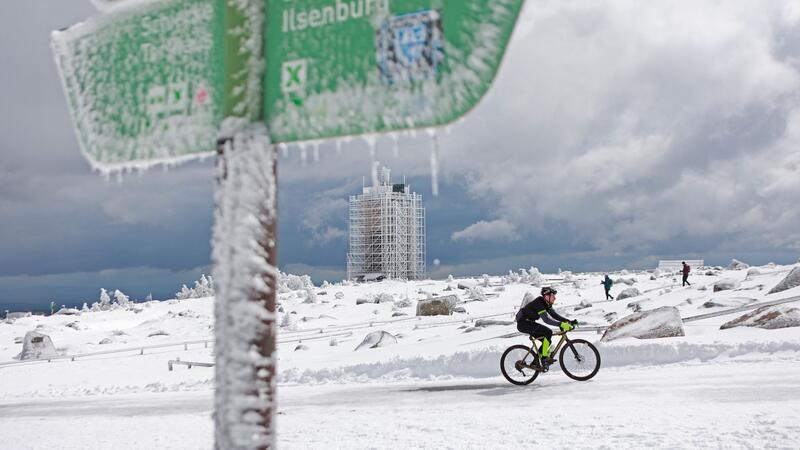 Ein Radfahrer ist auf dem schneebedeckten Brocken unterwegs.