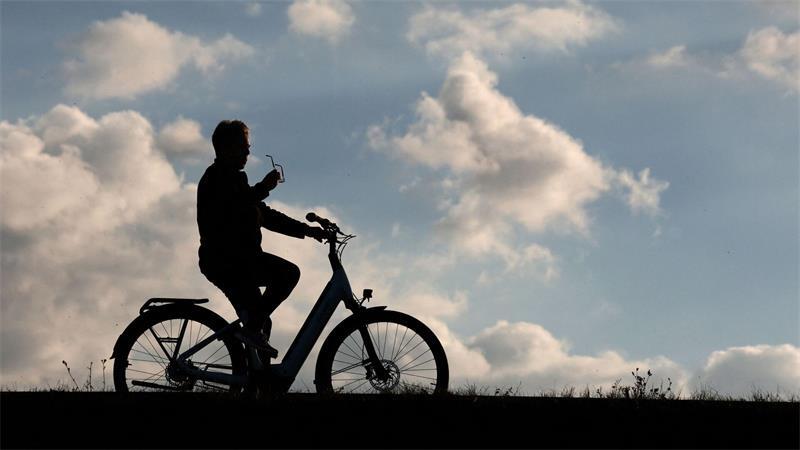 Ein Radfahrer ist mit seinem Fahrrad auf der Dammkrone des Stausees Kelbra unterwegs.