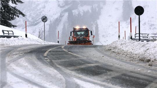 Ein Räumfahrzeug des Winterdienstes fährt auf dem Riedbergpass im Schneetreiben.