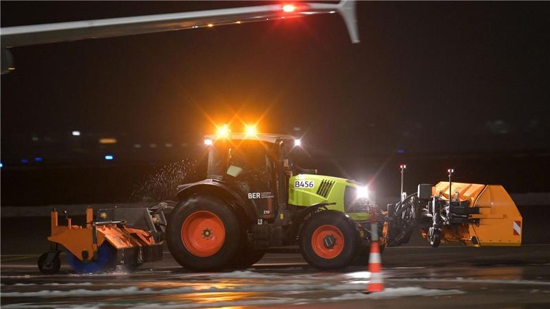 Ein Räumfahrzeug fährt über das Flugfeld des Berliner Flughafen BER.