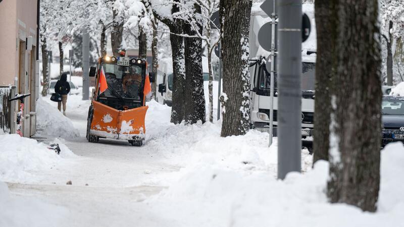 Winterwetter führt zu Flughafen-Stillstand in München Ein Räumfahrzeug fährt über einen verschneiten Weg in München.