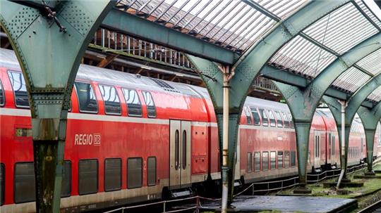 Ein Regional-Express der Deutschen Bahn steht an einem Bahnsteig in der historischen Gleishalle.