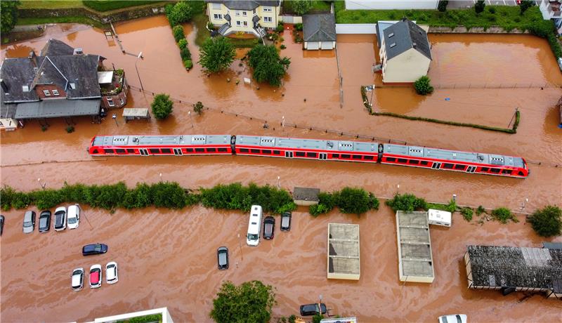 Ein Regionalzug steht im Bahnhof des Ortes im Wasser. Der Ort ist vom Hochwasser der Kyll überflutet. Foto: Sebastian Schmitt/dpa