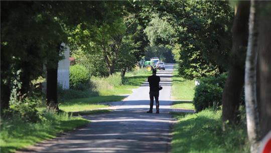 Ein Reporter steht auf einem Weg in Behrste.