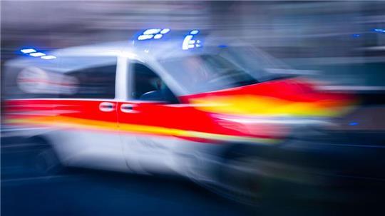 Ein Rettungsfahrzeug ist mit Blaulicht auf einer Straße unterwegs. (zu dpa: «Zug erfasst Auto – Fahrerin stirbt»)