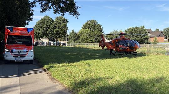 Ein Rettungshubschrauber ist auf einer Wiese gelandet. 