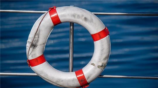 Ein Rettungsring hängt am Seezaun eines Hausboot ist in einem Hafen an der Ostsee.