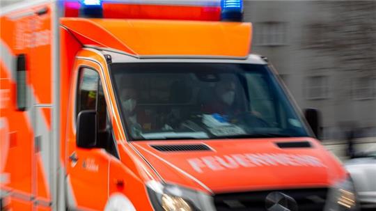 Ein Rettungswagen der Feuerwehr fährt auf einer Straße.