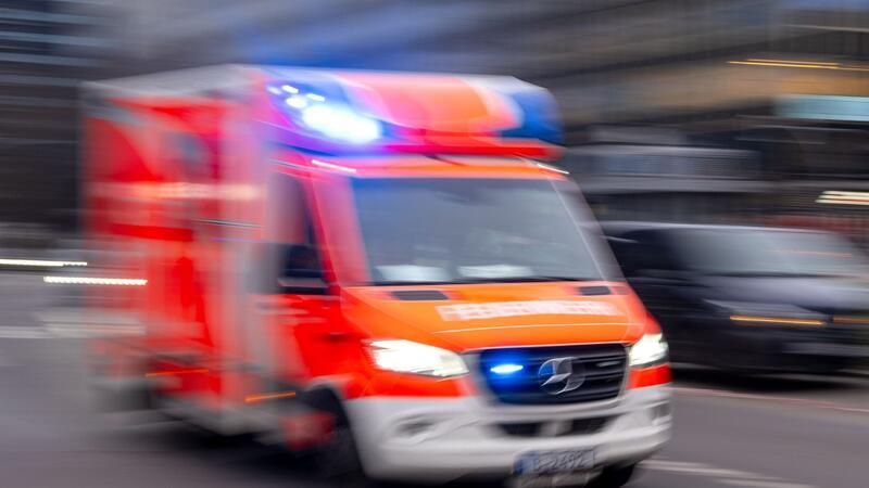 Ein Rettungswagen der Feuerwehr fährt mit Blaulicht zum Einsatz (Aufnahme mit Langzeitbelichtung).