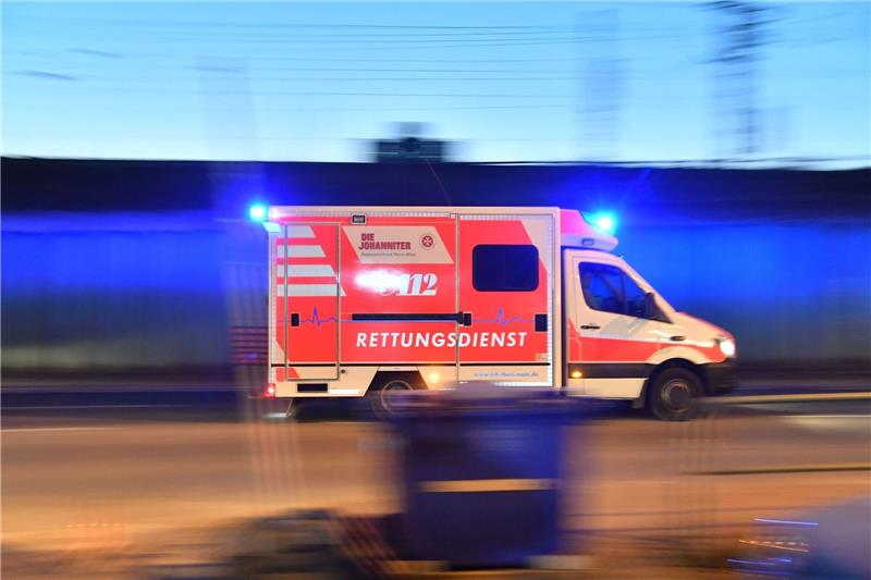Ein Rettungswagen ist mit eingeschaltetem Blauchlicht im Einsatz.
