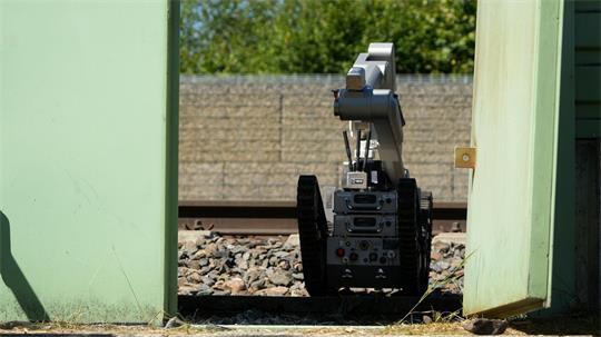 Ein Roboter ist auf dem Bahnhofsgelände im Einsatz.