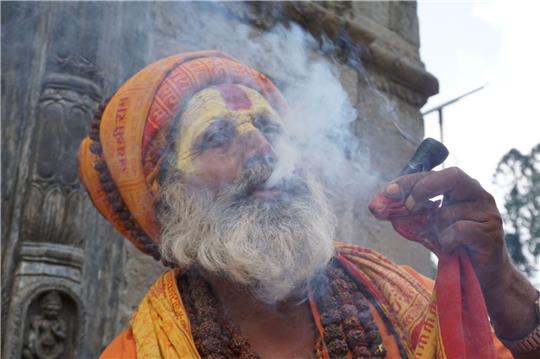 Ein Sadhu (ein heiliger Mann) raucht Marihuana auf dem Gelände eines Tempels in Kathmandu.