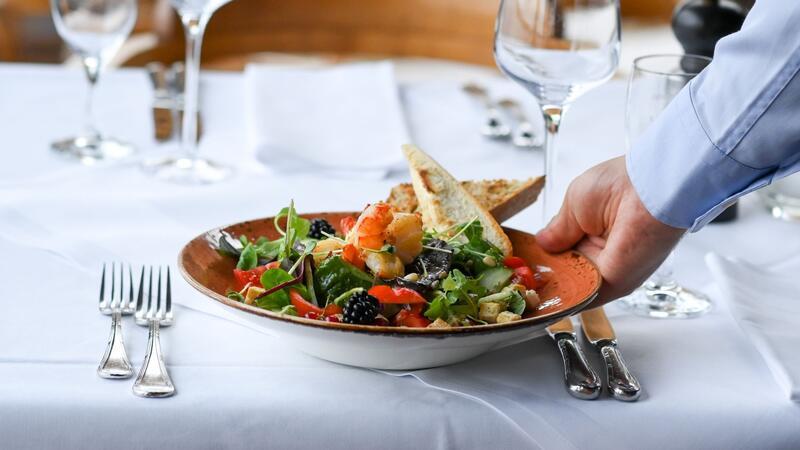 Restaurantbesuch könnte noch mal deutlich teurer werden Ein Salat-Teller wird in einem Restaurant serviert. Essengehen wird im kommenden Jahr noch einmal deutlich teurer.