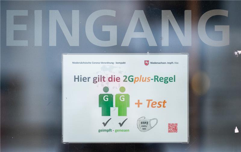 Ein Schild "Hier gilt die 2Gplus Regel" hängt am Eingang eines Kinos.