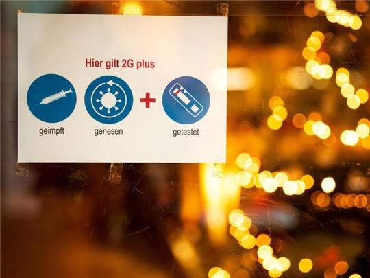 Ein Schild an der Tür eines Restaurants weist auf die 2G-Plus-Regel hin. Foto: Sina Schuldt/dpa/Archvbild