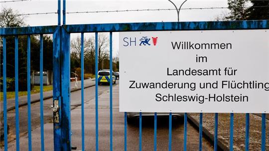 Ein Schild ist an einem Zaun der Landesunterkunft im Kreis Nordfriesland angebracht.