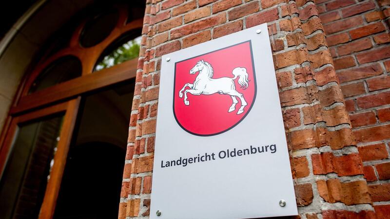 Ein Schild mit dem Landeswappen hängt am Eingang zum Landgericht Oldenburg.