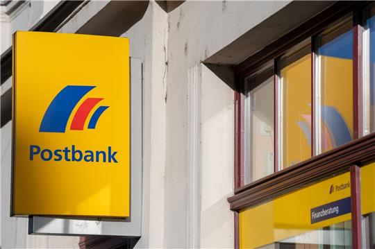 Ein Schild mit dem Logo der Postbank an der Fassade einer Bankfiliale in Brandenburg an der Havel.