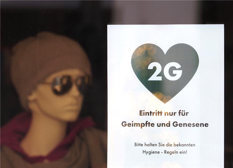 Ein Schild mit der Aufschrift „2G - Eintritt nur für Geimpfte und Genesene“ hängt im Schaufenster eines Modegeschäftes. Foto: Soeren Stache/dpa-Zentralbild/dpa