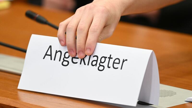 Diebstahl im Juweliergeschäft - Prozessbeginn verzögert sich Ein Schild mit der Aufschrift „Angeklagter“ wird auf die Gerichtsbank gestellt.