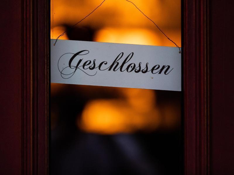 Ein Schild mit der Aufschrift "Geschlossen" hängt an einer Eingangstür. Foto: Rolf Vennenbernd/dpa/Archivbild